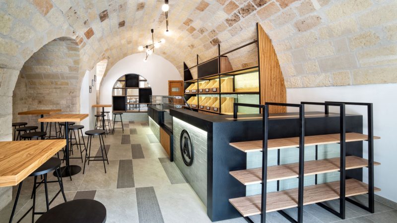 Interno Panificio Anselmo, bancone a destra, sgabelli e tavoli a sinistra, volta con lampade a sfere