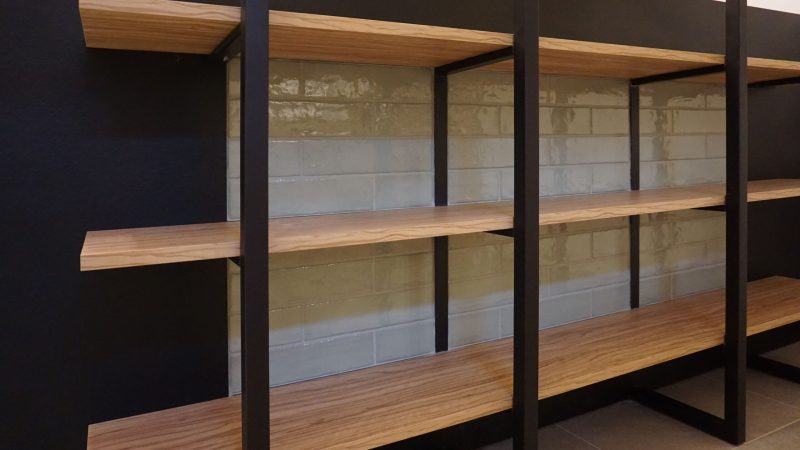 Dettaglio espositore prodotti Panificio Anselmo in legno d’ulivo e parti nere laccate