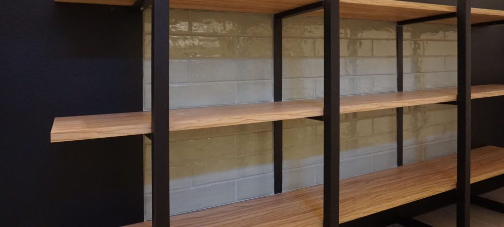 Dettaglio espositore prodotti Panificio Anselmo in legno d’ulivo e parti nere laccate