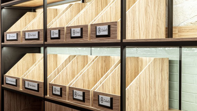 Espositore Panificio Anselmo in legno d’ulivo e parti nere laccate con contenitori prodotti di panificazione