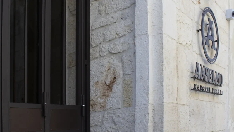 Facciata in pietra del Panificio Anselmo con ingresso e logo