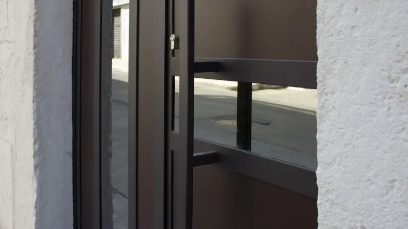 Dettaglio portone ingresso Panificio Anselmo in metallo testa di moro